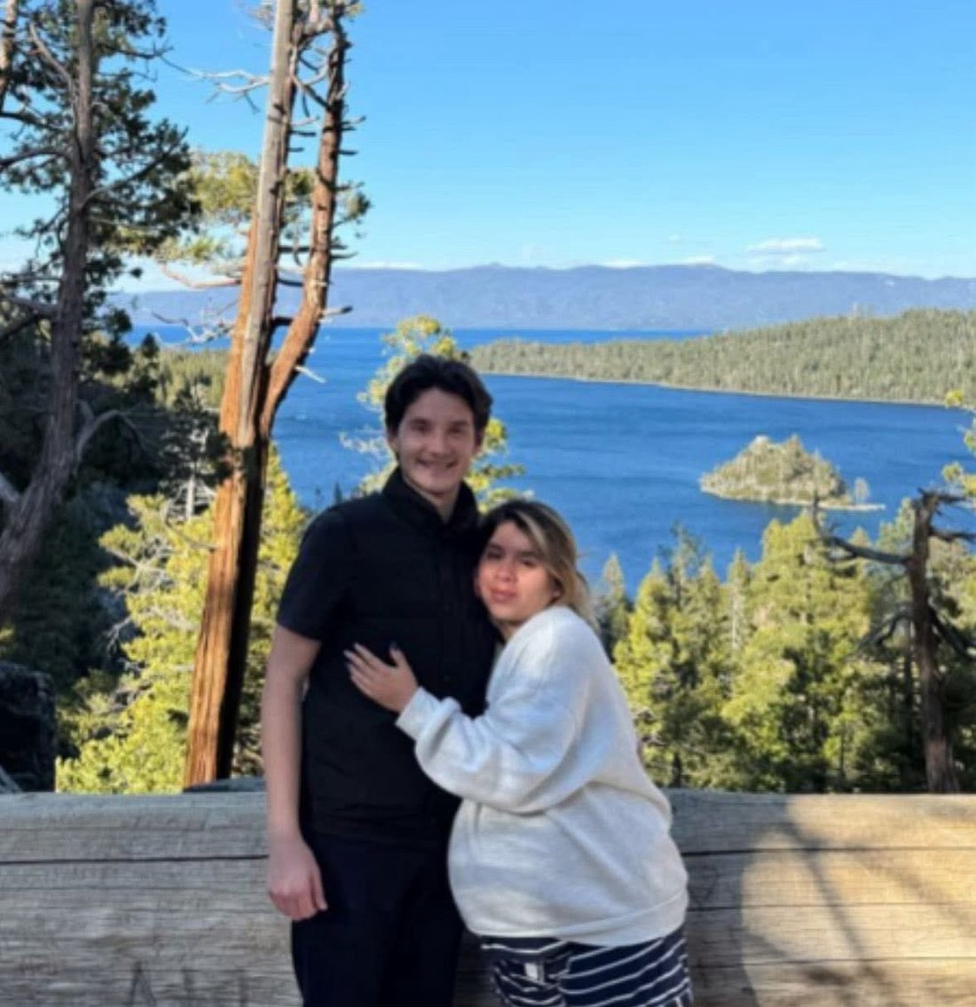 Joshua Hacket and Valeria Hacket standing together in front of a lake